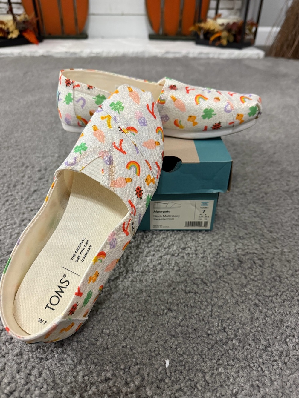 TOMS women’s White Canvas Slip-Ons with Rainbow & Clover Print